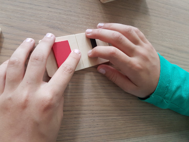 twee handen die met het Vormen voeldomino spelen