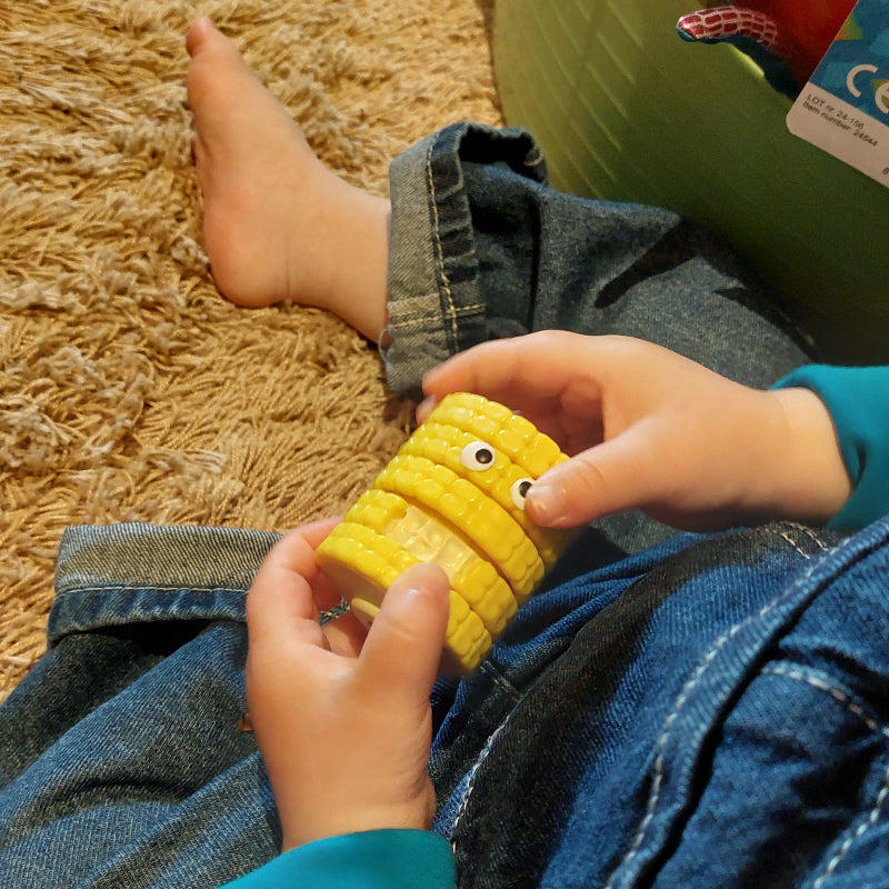 fidget mais in kinderhand, fidgetspeelgoed, mais speelgoed, draai speelgoed