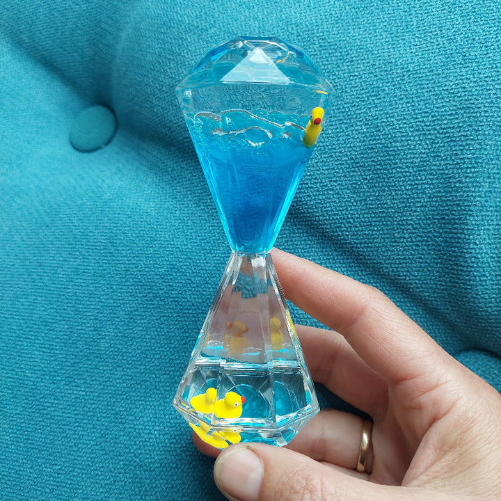 liquid lava loper, olieloper, olie zandloper, zandloper met olie, blauw met badeenjes in hand