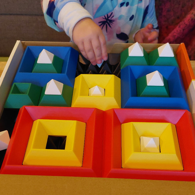 peuter speelt met piramiden puzzel, fijne motoriek speelgoed