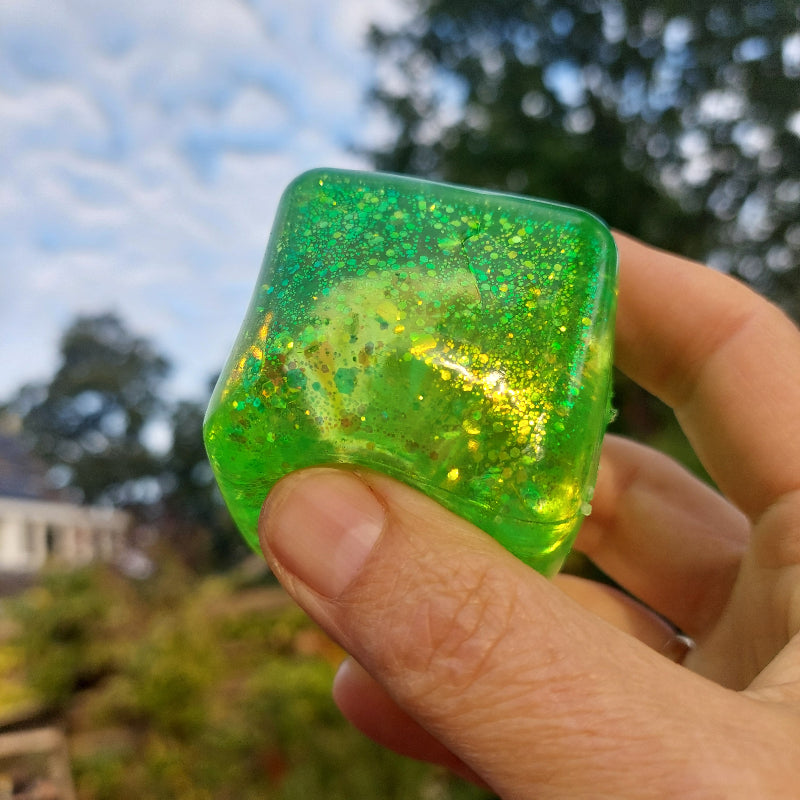 fidget kubus antistrssball groen in hand voor lucht