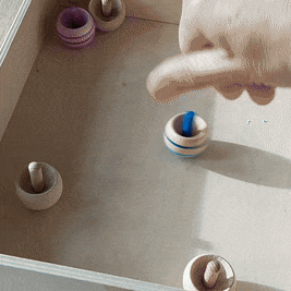 omkeertol  van goki, met streep, tollen in een bak, fijne motoriek speelgoed