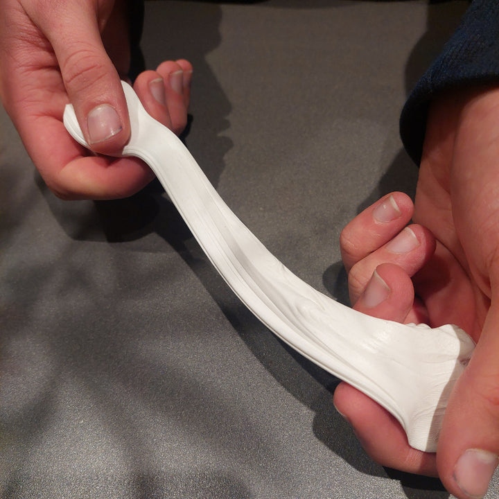 witte puty klei met twee handen uit elkaar trekken