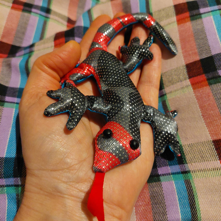 zanddier hagedis, mini zanddier, sensoriek materiaal, rood zwart zanddier op hand, achtergrond geruit deken