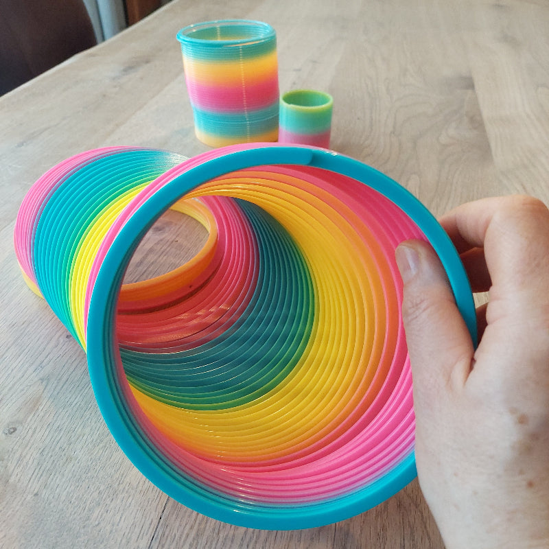 traploper doorsnee 15cm, op de achtergrond traploper 5cm en 10cm. hand houd traploper vast, motoriekspeelgoed