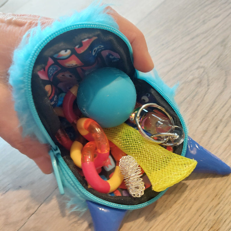 binnenkant van rits etui met fidgets, needoh, tangle, acupressuur ring, toverstaf