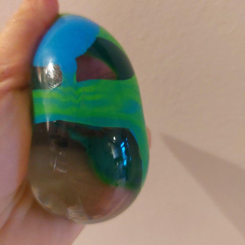 needoh marblees, knikker kleurige anti stressbal, hier in blauw groen, gedrukt in hand, fidget bal