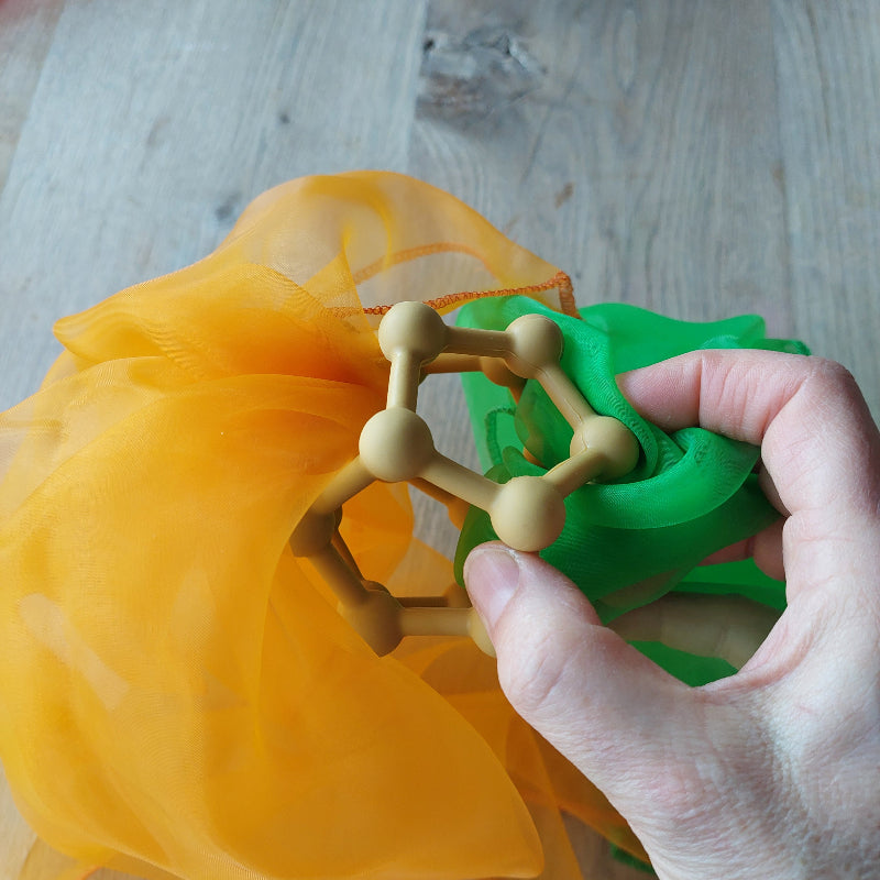 motoriekbal van rammelaartje, gele motoriek bal met noppen, bijtring, grijpbal, motoriekspeelgoed, in combinatie met een speeldoek in oranje en groen