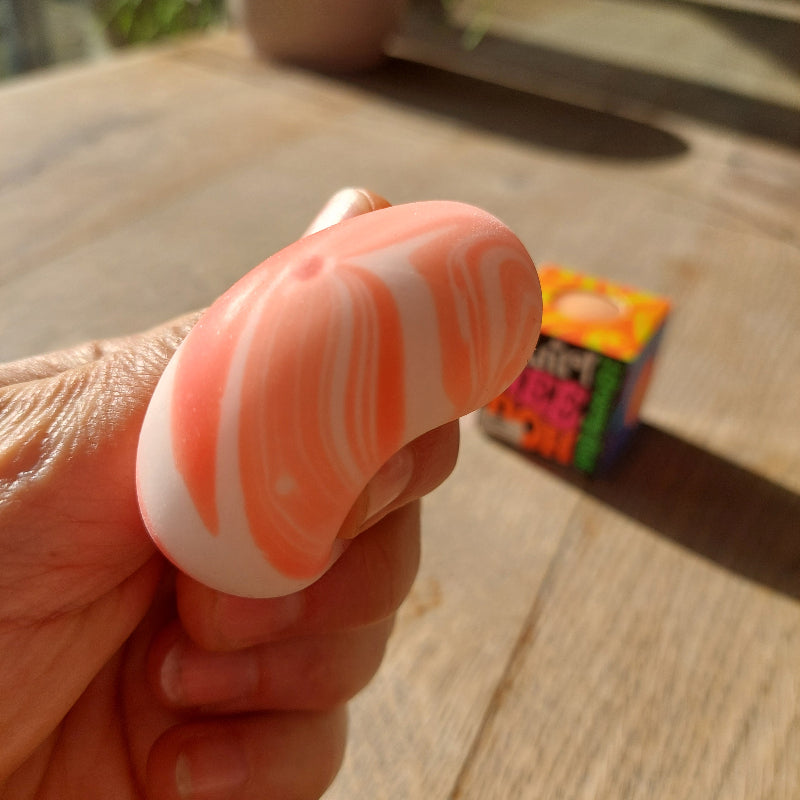 teenie needoh in hand, tussen vingers gedrukt, sensorische anti stressball, kleine antistressbal van needoh