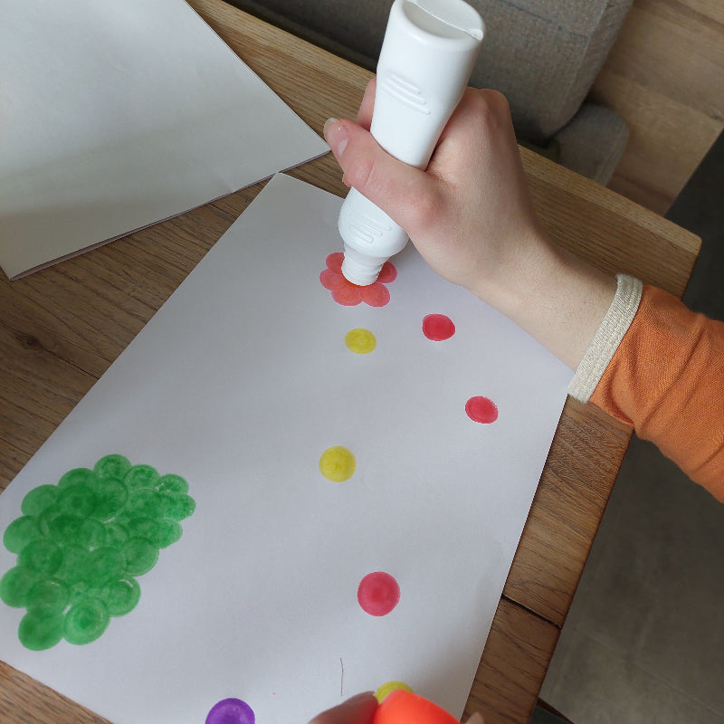 Kind maakt stippenkunst met ergonomische tupferstiften