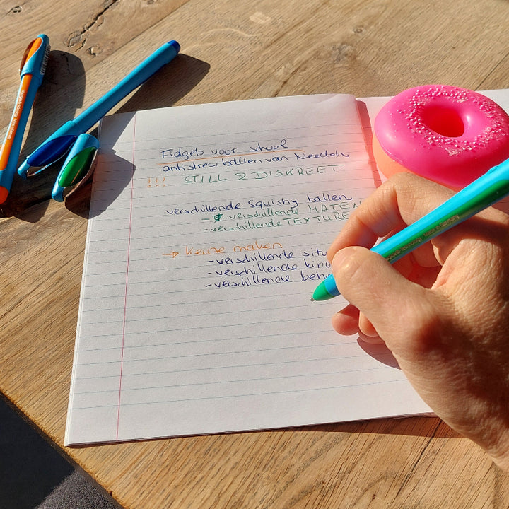 fidget donut naast schrift met balpen memo slider von schneider, motoriekmateriaal