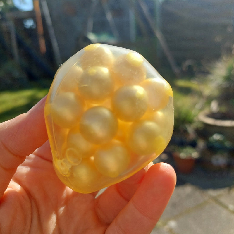 asml fidget bal, zachte balhoes met harde kralen binnen in voor prettig geluid bij het kneden, hand met gouden bal