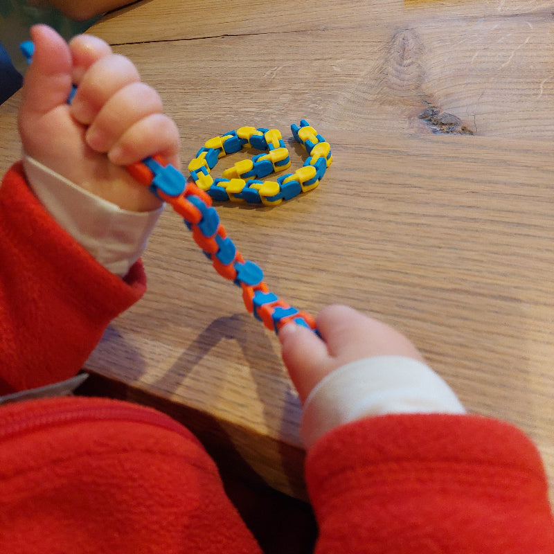 fidget eindeloze slang, schakel fidget, tweehandig buigen en knikken, motoriekspel, kind aan het spelen