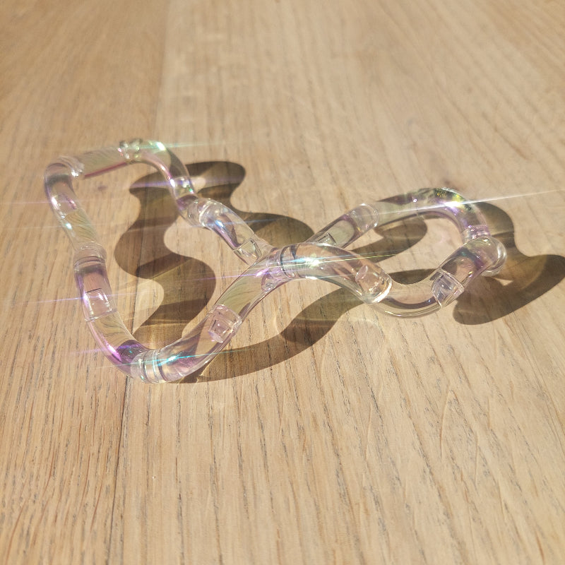 transparente tangle met licht reflexie op houten tafel, fidget tangle gem