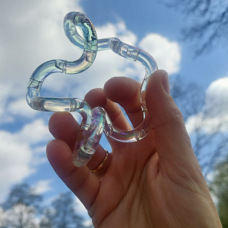 gem tangle transparent, in hand voor blauwe lucht met witte wolken, fidget tangle