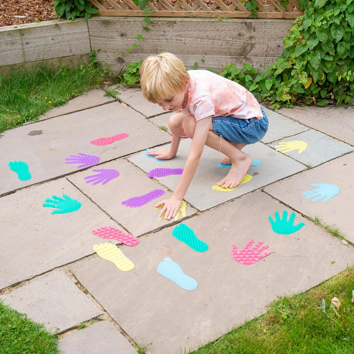 Kind speelt actief met handen en voeten op sensorische matjes en ontdekt verschillende texturen