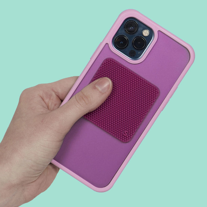 de paarse vierkante slabs sticker van speks op een telefoon in de hand gehouden. silicone sticker als fidget voor prikkelverwerking