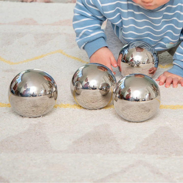 mysterieballen, sensoriekballen, spiegelballen , geluidsballen, babyballen, met kruipend kind op kleed