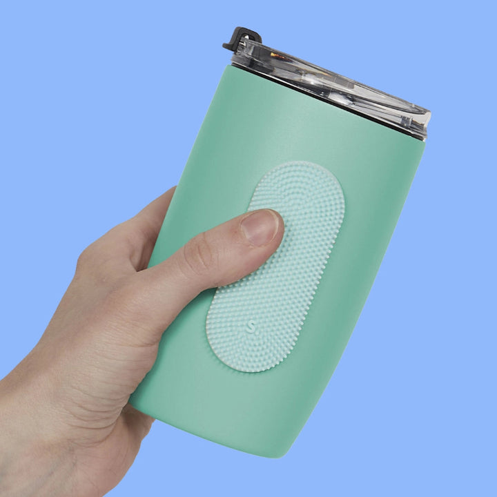 sensoriek sticker op een drinkfles, groene fles in hand met blauwe achtergrond, speks slabs