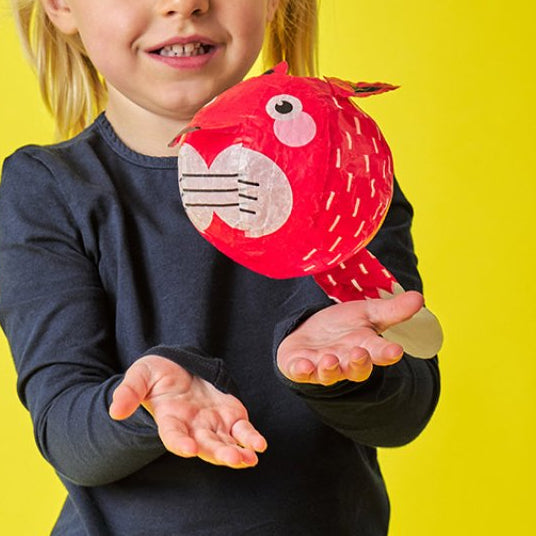 Kind laat voorzichtig een papieren ballon zweven, motoriek en sensoriek speelgoed