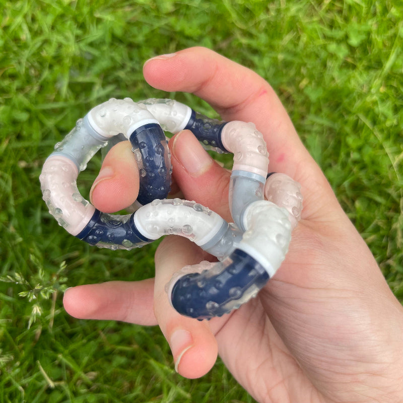 tangle relax therapy in hand, achtergrond grass