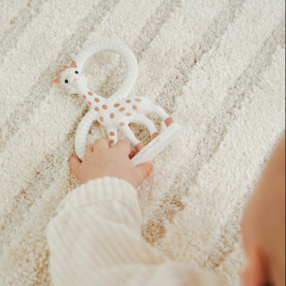 Babyhandje houdt Sophie de giraf bijtring met dubbele ringen stevig vast