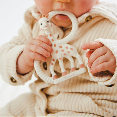 Baby bijt op Sophie de giraf bijtring van natuurlijk rubber bij doorkomende tandjes
