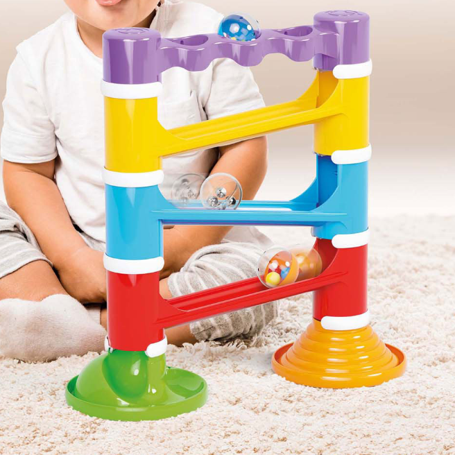 Kind speelt met Quercetti Migoga knikkerbaan toren en volgt de rollende grote geluidsballen