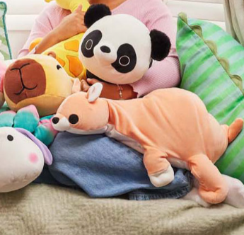kind op bank met heel veel verzwaarde knuffels panda, 