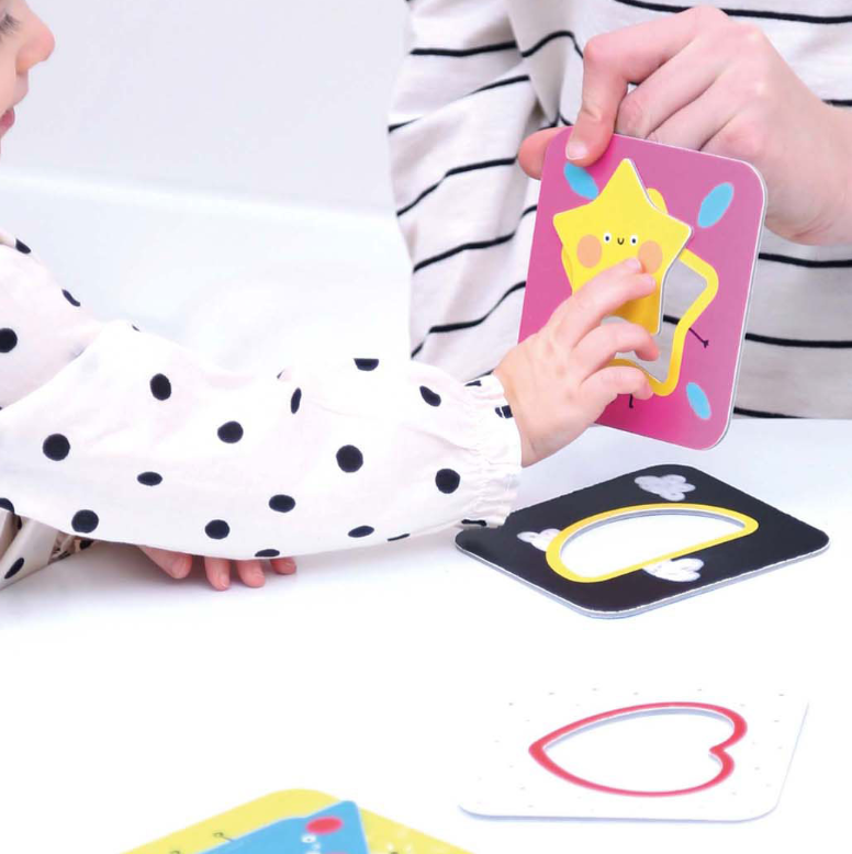 kinderhand wijst naar ster puzzelstuk van het banana panda vormenpuzzel met hoge contrasten