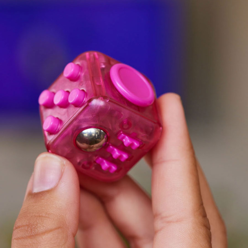 roze fidget cube van zuru in hand, verschillende kanten dobbelsteen, fidget dobbelsteen