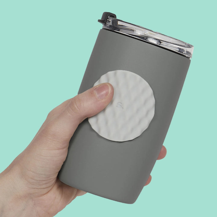 Ronde Speks Slab voor subtiele sensorische prikkelverwerking, grijze sticker op grijze drinkfles met duim, volwassenen fidget