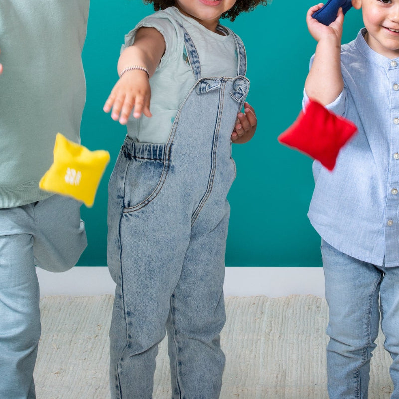 Kinderen gooien een pittenzakjes binnen, kinderen van verschillende leeftijd met spijkerbroeken, motoriekspel