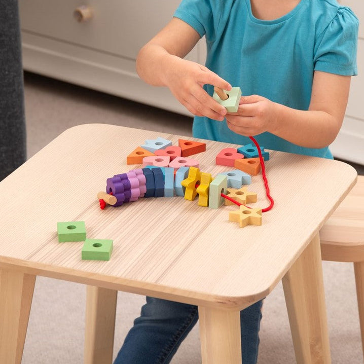 Kind rijgt Tickit regenboog houten vetervormen en oefent fijne motoriek en concentratie