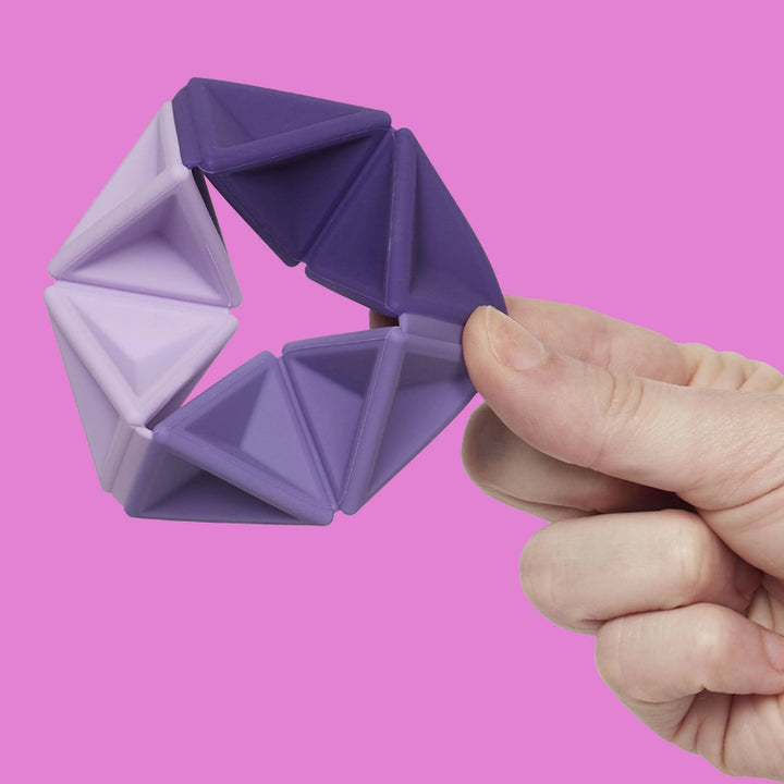 Speks Pivot flexagon voor sensorische prikkelverwerking, paars in hand voor roze achtergron