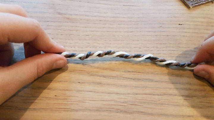 handen die Wikki Stix in natuurlijke kleuren oprollen tot meerkleurige strick, tweehandig werken, hand oog coordinatie