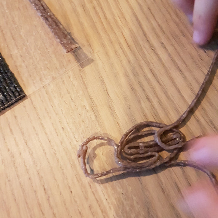 handen die Wikki Stix in natuurlijke kleuren buigen en vormen tot figuren, fijne motoriek knutselmateriaal, herbruikbaar