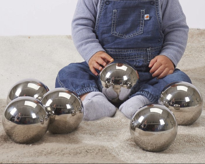 kind zit op kleed met 6 sensorisch spiegelballen, sensoriek speelgoed